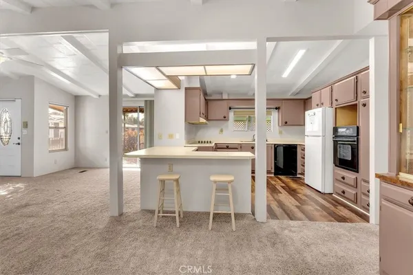 a view of kitchen with stainless steel appliances cabinets and a window