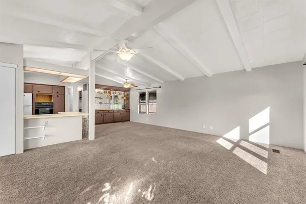 an empty room with windows and ceiling fan