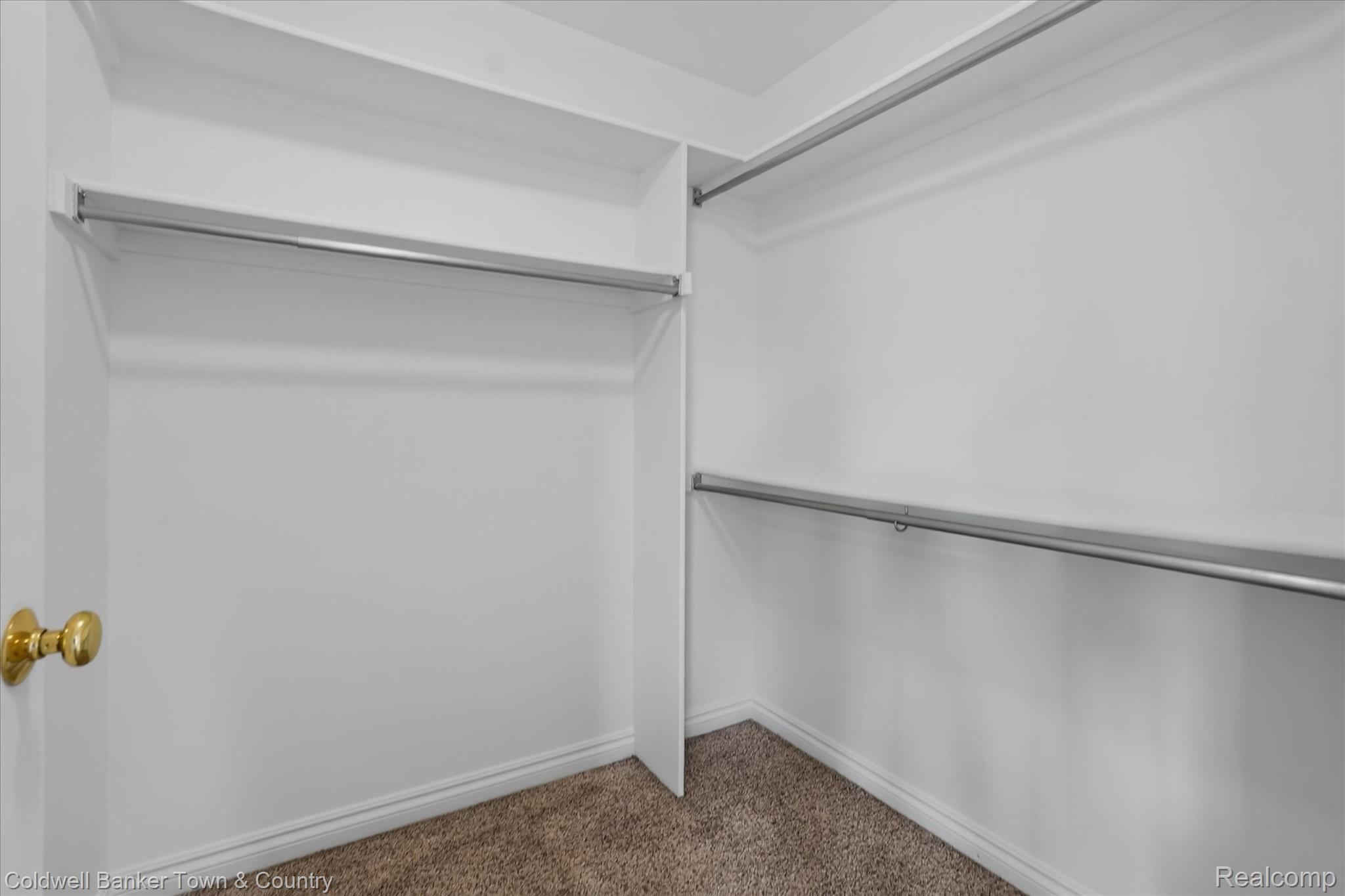 1725 Town Commons Drive Howell, MI 48855 - Photo 32 of 53 Walk-in closet featuring built-in shelving, chrome hanging rods, neutral carpeting, and white baseboards