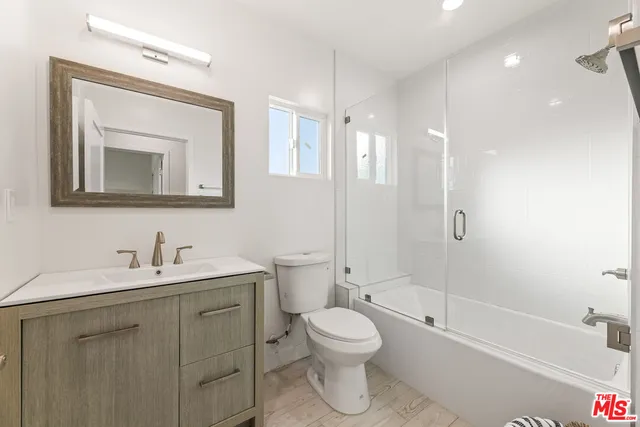 a bathroom with a bathtub shower sink vanity and toilet