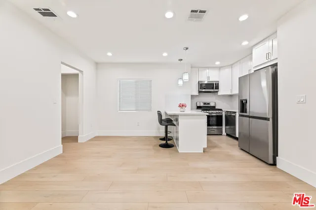 a view of a kitchen with a sink and wooden floor