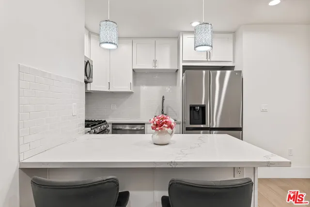 a kitchen with stainless steel appliances granite countertop white cabinets a sink and dishwasher