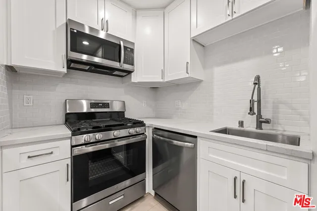 a kitchen with kitchen island a sink and a stove top oven