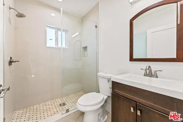 a bathroom with a sink a toilet a shower and a mirror