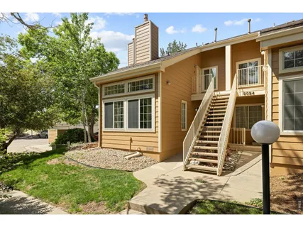 a view of a house with backyard and a tree