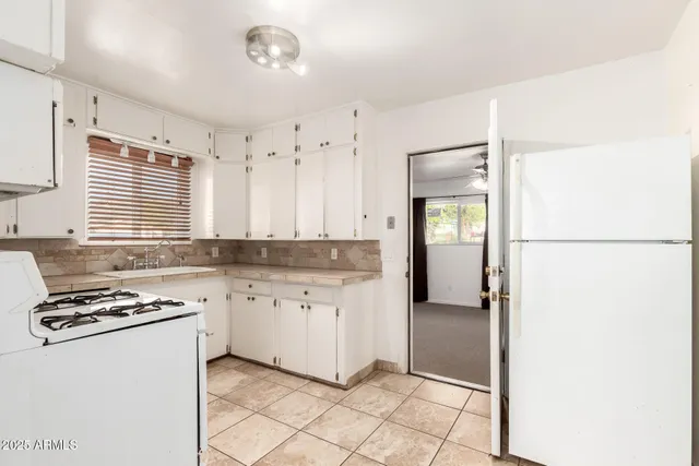 a kitchen with granite countertop a sink cabinets and stainless steel appliances