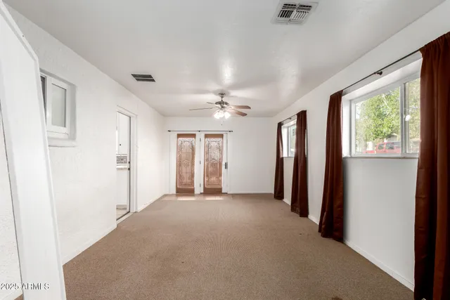 a view of a hallway with windows and chandelier