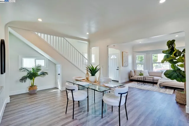 a dining room with furniture potted plants and wooden floor