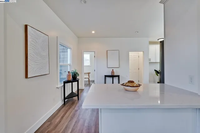 a kitchen with cabinets wooden floor and stainless steel appliances