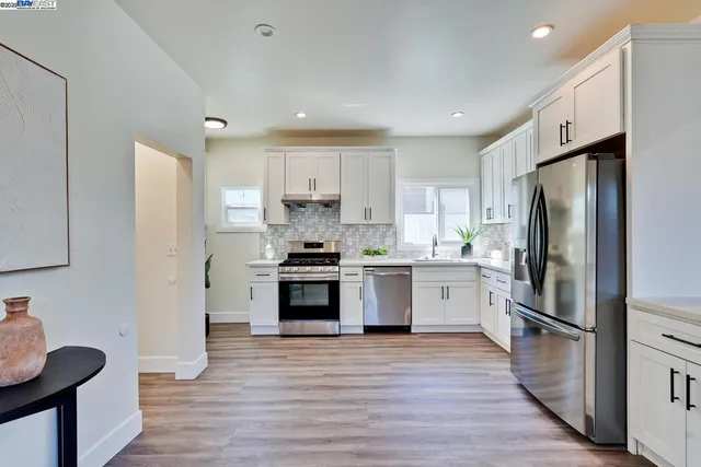 a kitchen with granite countertop a sink cabinets and wooden floor