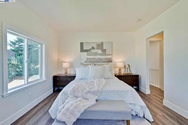 a bedroom with a bed and a lamp on dresser