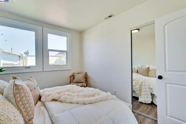 a bedroom with a bed and a potted plant