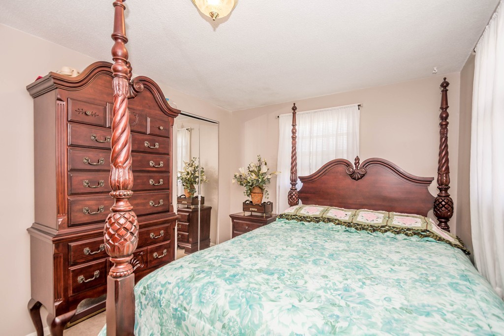 52 Westwind Road Lowell, MA 01852 - Photo 13 of 28 a bedroom with a bed and a dresser