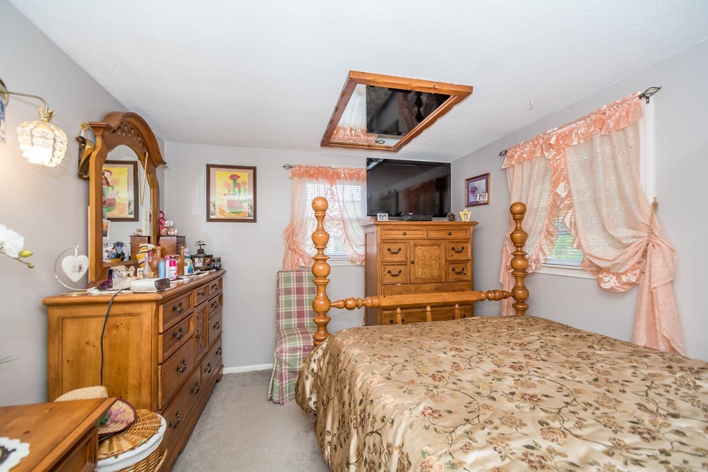 52 Westwind Road Lowell, MA 01852 - Photo 17 of 28 a bedroom with a bed and a tv on the dresser