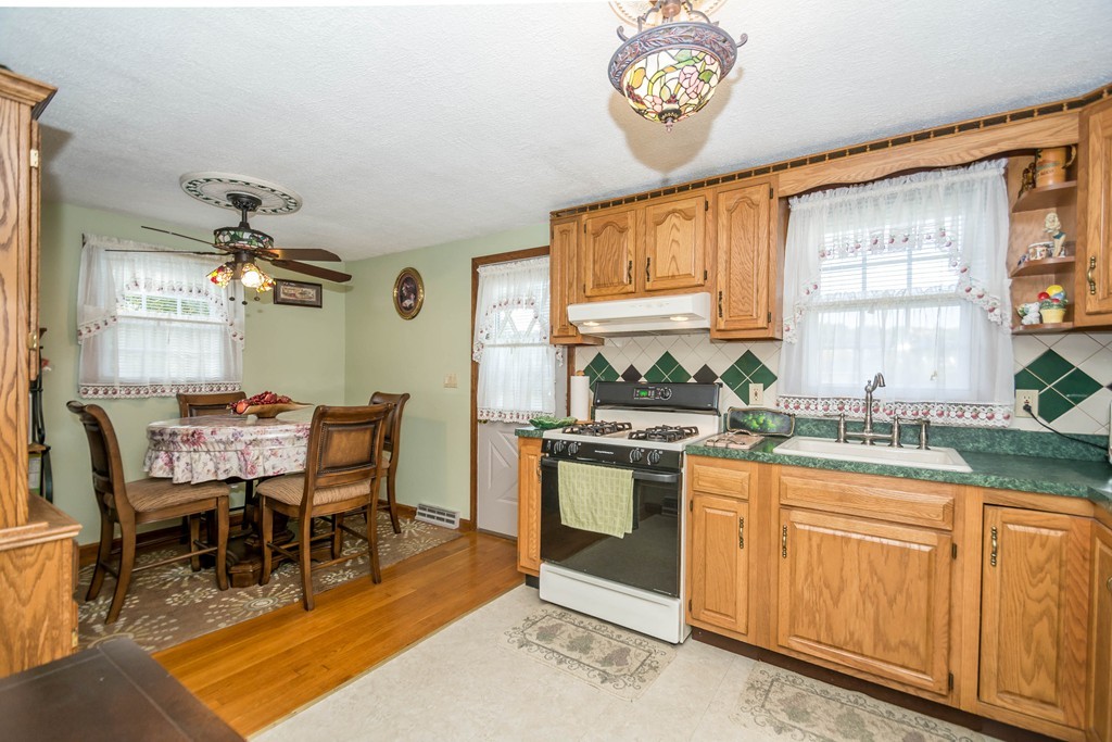 52 Westwind Road Lowell, MA 01852 - Photo 5 of 28 a kitchen with stainless steel appliances granite countertop a stove a sink dishwasher and cabinets with wooden floor