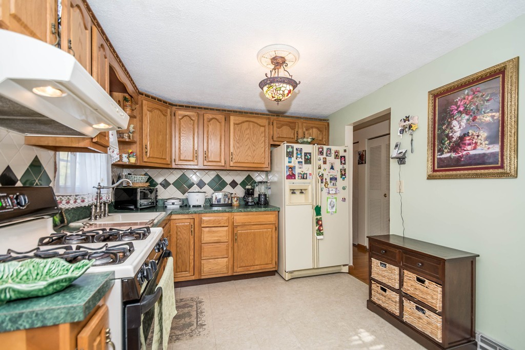 52 Westwind Road Lowell, MA 01852 - Photo 7 of 28 a kitchen with stainless steel appliances granite countertop a refrigerator a stove top oven a sink and dishwasher