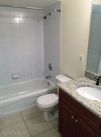 a bathroom with a granite countertop toilet sink and shower