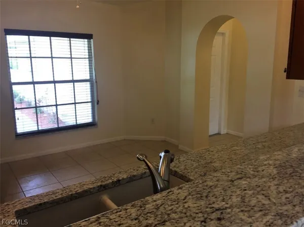 a bathroom with a granite countertop sink and a window