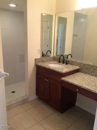 a bathroom with a granite countertop sink and a mirror