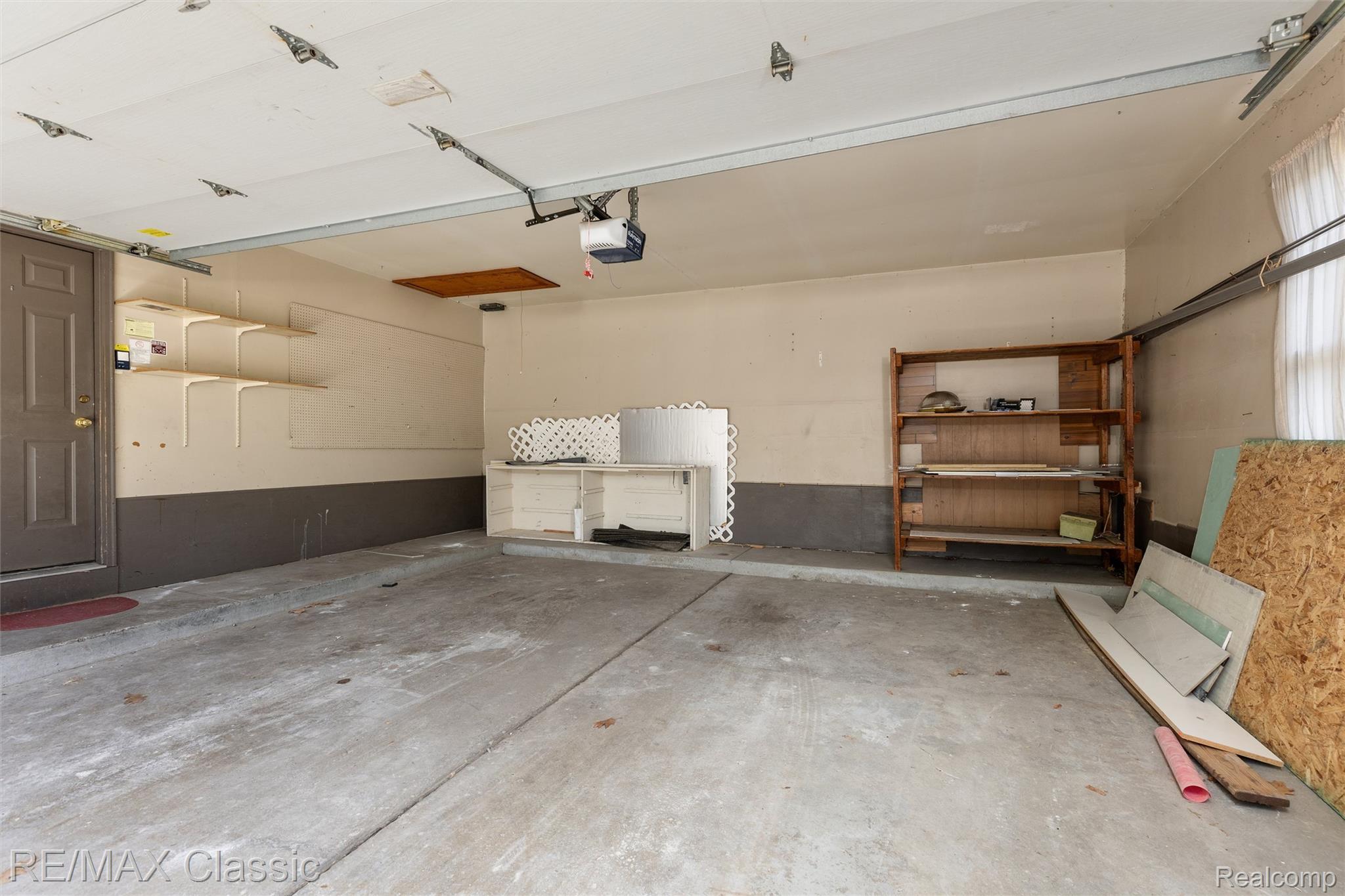 4268 Covered Bridge Road Bloomfield Hills, MI 48302 - Photo 29 of 35 Spacious garage featuring concrete flooring and a paneled entry door