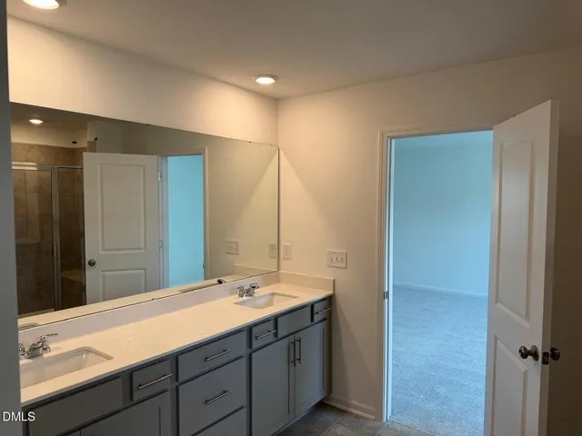 a bathroom with a double vanity sink and mirror
