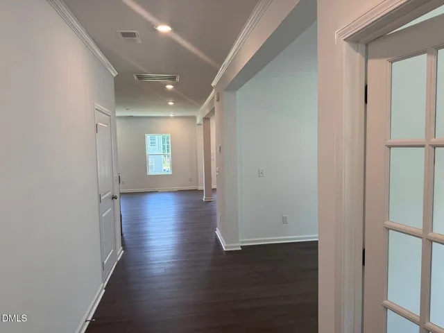 a view of empty room with wooden floor
