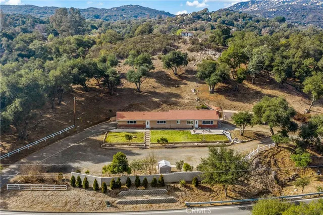 an aerial view of a house with a garden and lake view