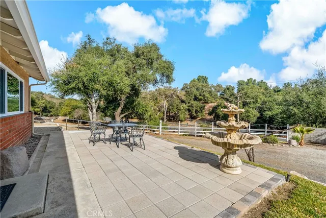 a view of a patio with dining table and chairs with wooden fence
