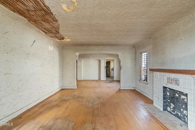 a view of a hallway with wooden floor and a fireplace