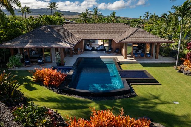 an aerial view of a house with swimming pool patio and outdoor seating