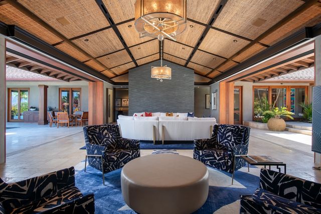 a living room with furniture a chandelier and a rug