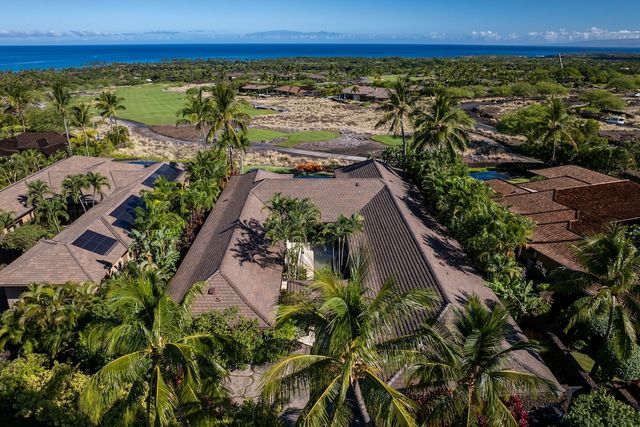 an aerial view of a house with a yard and a bench