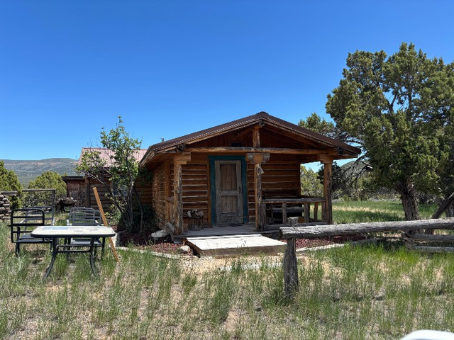 14908 North Deep Crk Road Lapoint, UT 84039 - Photo 5 of 9 Rustic log cabin exterior with a covered front porch and a prominent wooden railing
