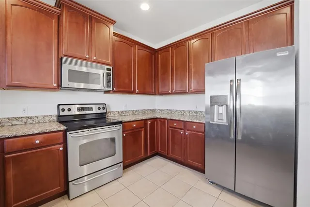 a kitchen with stainless steel appliances granite countertop a refrigerator stove and cabinets