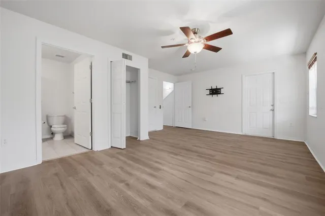 a view of a livingroom with a ceiling fan & entryway