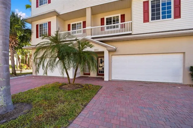 a front view of a house with a yard and palm trees