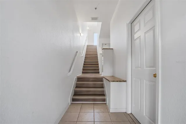 a view of a hallway with stairs and wooden floor
