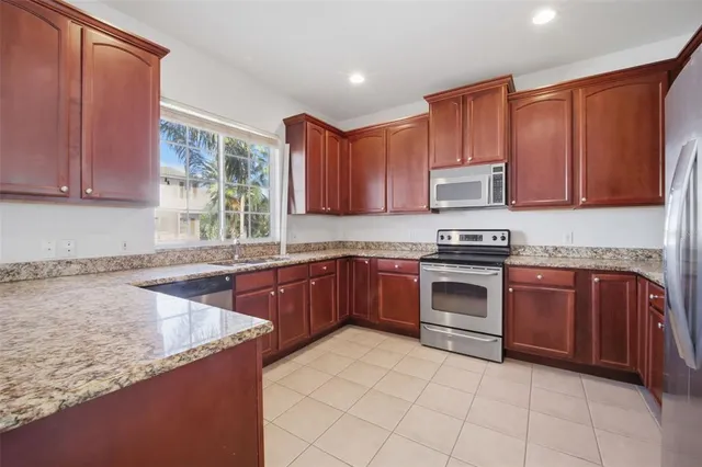 a kitchen with stainless steel appliances granite countertop a stove sink and cabinets