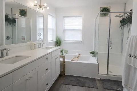 a bathroom with a double vanity sink mirror and bathtub