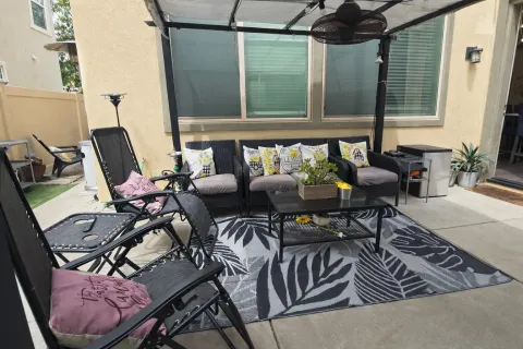 a view of two chairs and table in a patio