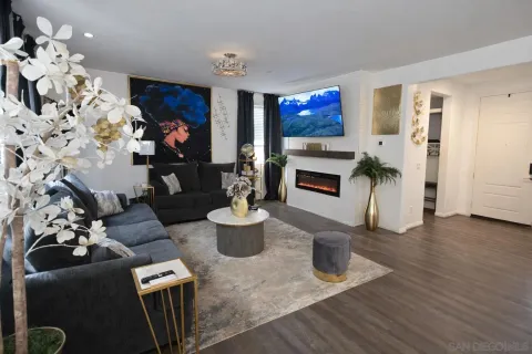a living room with furniture a flat screen tv and a fireplace