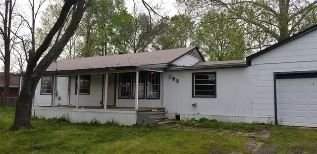 a front view of a house with a garden and yard