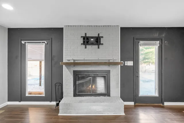 an empty room with a fireplace and wooden floor