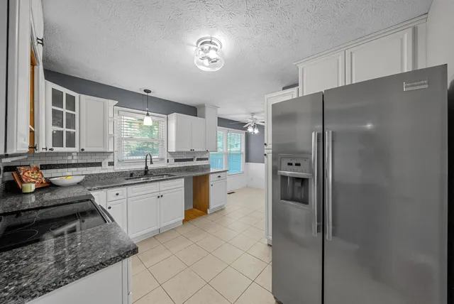 a large kitchen with a refrigerator a sink and dishwasher