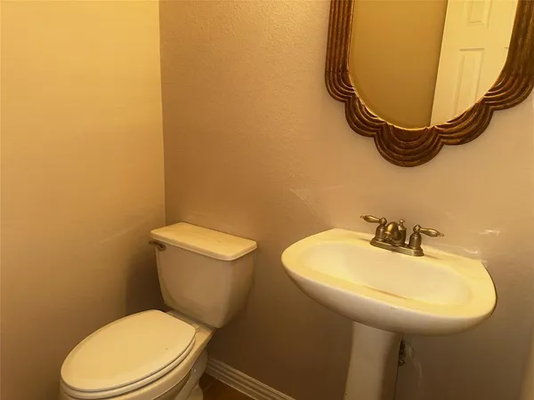 a bathroom with a sink mirror and toilet