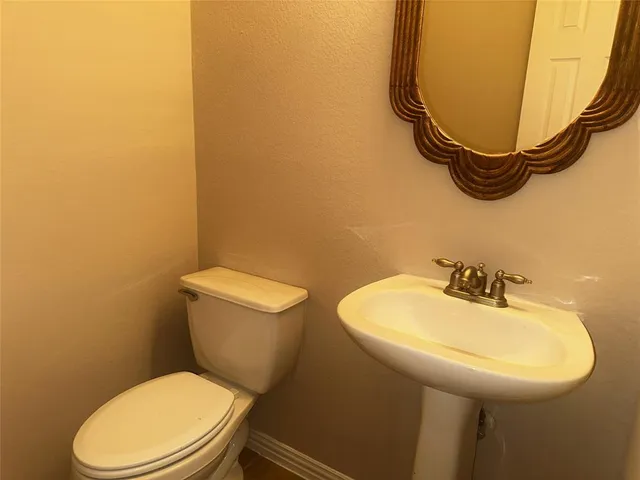 a bathroom with a sink mirror and toilet