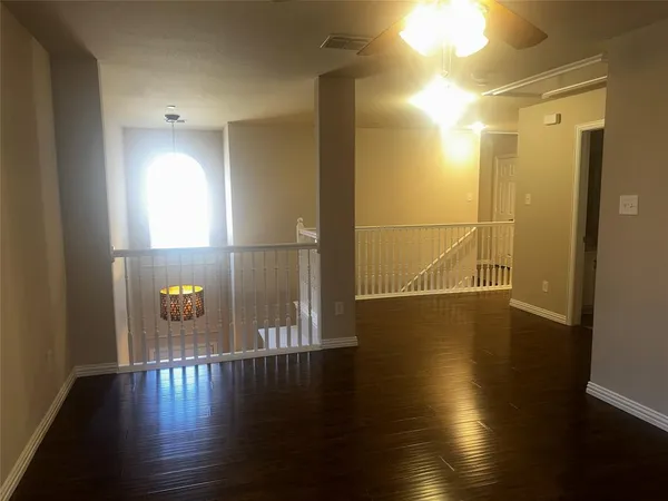 a view of empty room with wooden floor