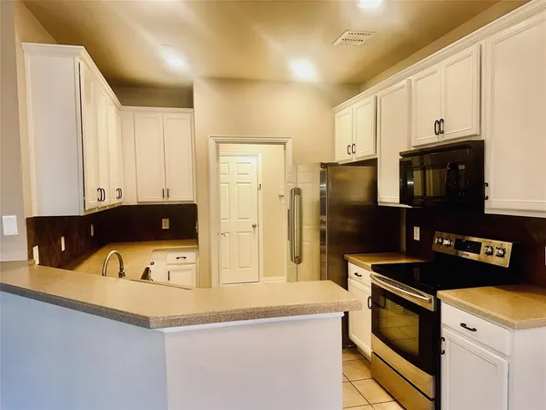 a kitchen with stainless steel appliances a stove a microwave a sink and cabinets