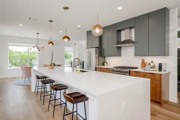 a kitchen with a table chairs stove and wooden floor