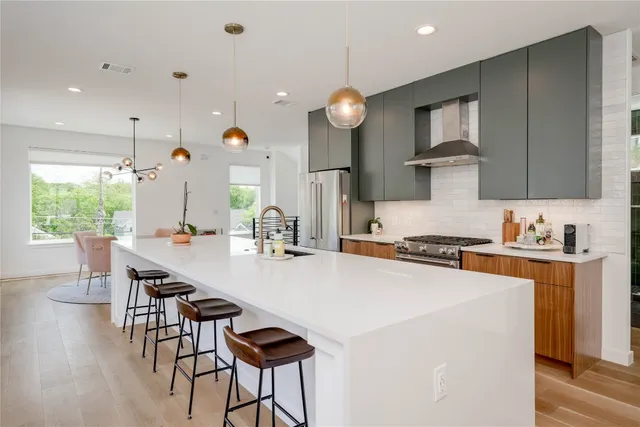 a kitchen with a table chairs stove and wooden floor